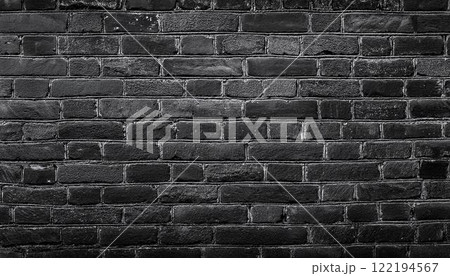 texture of an old black shabby brick wall with a distressed appearance, The dark masonry creates a grunge style aesthetic, perfect as a background or texture 122194567
