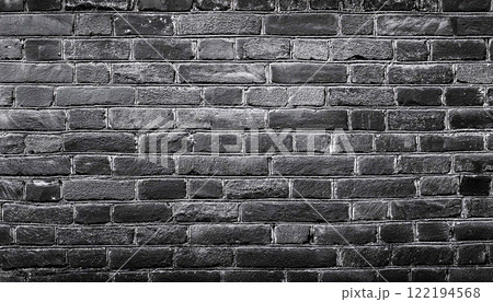 texture of an old black shabby brick wall with a distressed appearance, The dark masonry creates a grunge style aesthetic, perfect as a background or texture 122194568