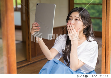 タブレット見て感動する若い女性 タブレット見て感動する若い女性 122195543