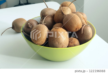 Group of kiwi with tails from home garden in bowl. Eco-friendly pure natural product. Group of kiwi with tails from home garden in bowl. Eco-friendly pure natural product. 122196088