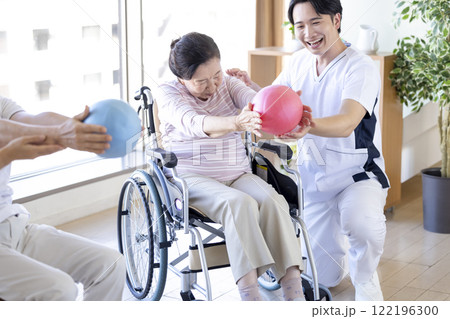 介護　ボールを使ってリハビリをするシニアと理学療法士 122196300
