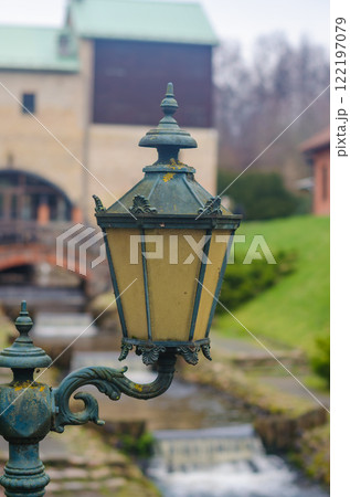 vintage lantern with ornate details, casting warm glow against blurred backdrop. High quality photo 122197079