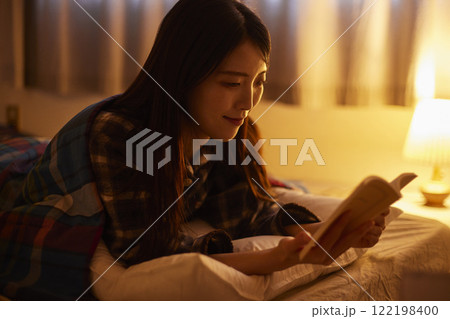 布団を被り読書をする日本人の女性 布団を被り読書をする日本人の女性 122198400