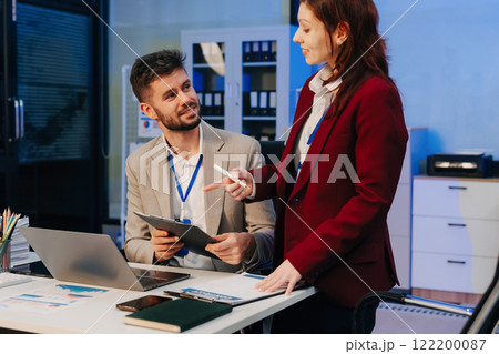 Diversity, business team working at office with laptop and documents on desk, financial adviser analyzing data, employees working overtime. Diversity, business team working at office with laptop and documents on desk, financial adviser analyzing data, employees working overtime. 122200087