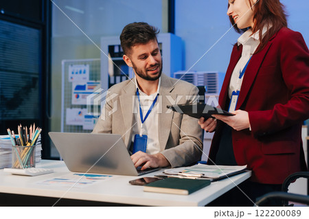 Diversity, business team working at office with laptop and documents on desk, financial adviser analyzing data, employees working overtime. Diversity, business team working at office with laptop and documents on desk, financial adviser analyzing data, employees working overtime. 122200089