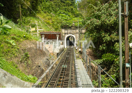 Penang Hill railway tracks leading into tunnel surrounded by lush greenery, steep incline funicular train route, scenic hillside view, popular travel destination, Malaysian heritage site Penang Hill railway tracks leading into tunnel surrounded by lush greenery, steep incline funicular train route, scenic hillside view, popular travel destination, Malaysian heritage site 122200329