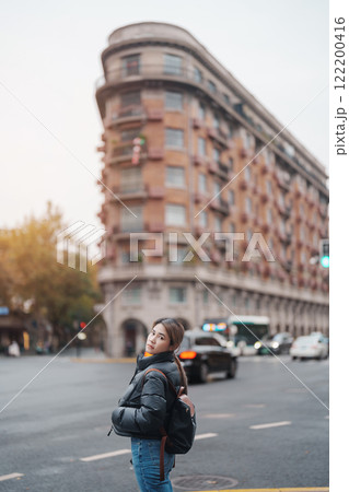 woman traveler visiting in Shanghai, China. Female Tourist with backpack sightseeing Wukang Mansion with Wukang Road and Middle Huaihai Road. landmark and popular for tourism attractions in Shanghai woman traveler visiting in Shanghai, China. Female Tourist with backpack sightseeing Wukang Mansion with Wukang Road and Middle Huaihai Road. landmark and popular for tourism attractions in Shanghai 122200416