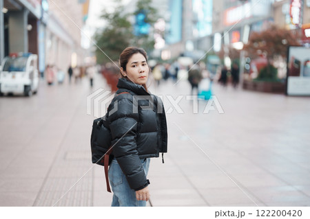 woman traveler visiting in Shanghai, China. Happy Female Tourist sightseeing in Nanjing road, shopping district of Shanghai. landmark and popular for tourism attractions. Travel and Vacation concept 122200420