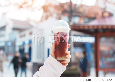 Woman hand holding iced Cheese grape boom tea, famous and popular beverage in Shanghai, China 122200422