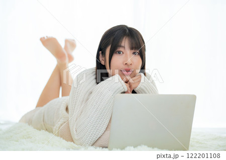 うつ伏せに寝てパソコンを操作する日本人女性 うつ伏せに寝てパソコンを操作する日本人女性 122201108
