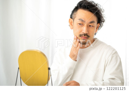 鏡で肌を確認する日本人男性 122201125