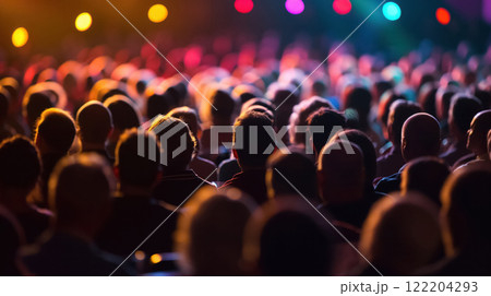 Crowded audience under colorful stage lights. 122204293