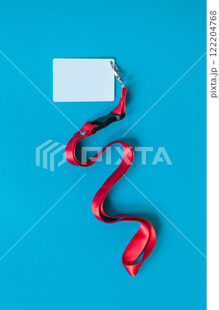 White plastic badge, red Lanyard with blank space mock up isolated on blue background White plastic badge, red Lanyard with blank space mock up isolated on blue background 122204768