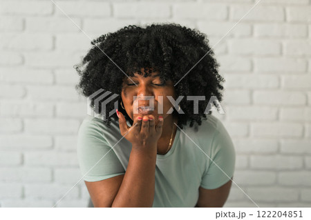 Catch my kiss. Lovely romantic African American woman air kissing over palms hands, sending love. Beauty care and Valentines day concept Catch my kiss. Lovely romantic African American woman air kissing over palms hands, sending love. Beauty care and Valentines day concept 122204851