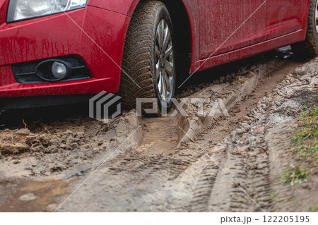 Car stuck in the mud, car wheel in dirty puddle, rough terrain Car stuck in the mud, car wheel in dirty puddle, rough terrain 122205195