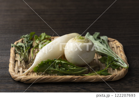 木目テーブルに置かれた竹笊と春の七草とコピースペース 122207693