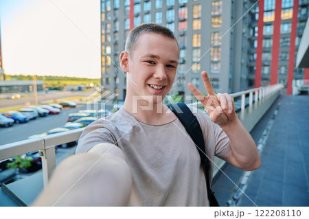 Selfie portrait of young happy teenage guy, outdoor 122208110