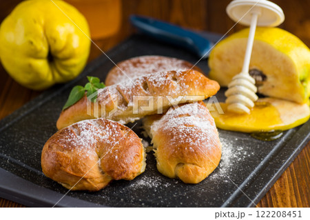 Pastries. Sweet buns with quince and honey filling, on a wooden table 122208451