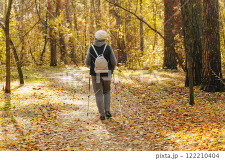 Embracing autumn's beauty through Nordic walking in a tranquil forest trail 122210404