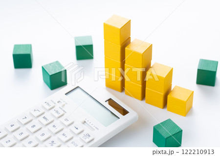 黄色の積み木でできたグラフと電卓 122210913