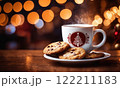 Merry Christmas and Happy Holidays. A cup of hot drink and cookies with background of the lights of Christmas market. Cup of coffee on the window sill. Bright lights of the city hristmas background. 122211183