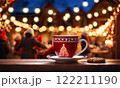 Merry Christmas and Happy Holidays. A cup of hot drink and cookies with background of the lights of Christmas market. Cup of coffee on the window sill. Bright lights of the city hristmas background. 122211190