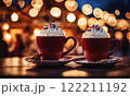 Merry Christmas and Happy Holidays. A cup of hot drink and cookies with background of the lights of Christmas market. Cup of coffee on the window sill. Bright lights of the city hristmas background. 122211192