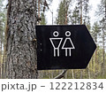 Sign indicating restroom facilities for men and women in a forested area. Comfortable environment in the park 122212834