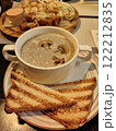 Delicious bowl of creamy mushroom soup with toasted bread served at a cozy restaurant in the evening 122212835