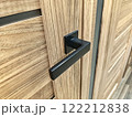 Modern black door handle on a wooden cabinet showcasing sleek design in a contemporary interior setting 122212838