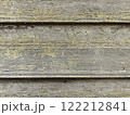 Weathered wooden wall with peeling paint and moss growth in a rural setting. Natural background 122212841
