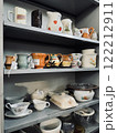 Flea market shelves with old mugs, jugs, and other crockery. Vintage shop interior. 122212911