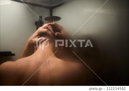 A person is enjoying a refreshing shower while using shampoo in a modern bathroom setting 122214582