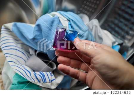Using Laundry Detergent Pods While Doing Laundry in the Washing Machine with Clothes 122214636