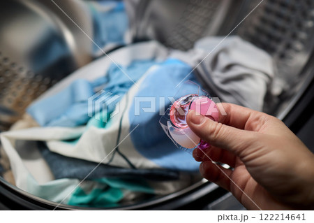 Using Laundry Detergent Pods While Doing Laundry in the Washing Machine with Clothes 122214641