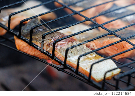 Grilled trout fish sizzling on the barbecue, filling the air with enticing smoky aromas at sunset Grilled trout fish sizzling on the barbecue, filling the air with enticing smoky aromas at sunset 122214684