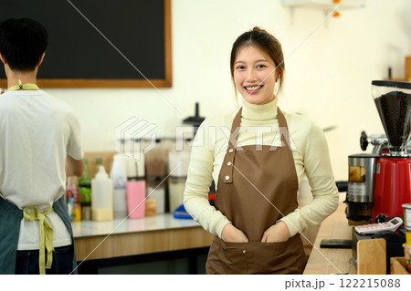 Portrait of confident coffee shop owner standing behind the counter, ready to serve customers Portrait of confident coffee shop owner standing behind the counter, ready to serve customers 122215088