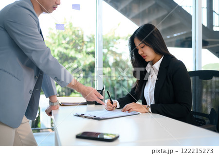 Female candidate in formal suit signing an agreement or application during job interview Female candidate in formal suit signing an agreement or application during job interview 122215273