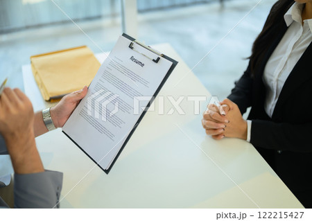 Cropped shot of employer holding a clipboard listens and evaluates candidate during an interview. Cropped shot of employer holding a clipboard listens and evaluates candidate during an interview. 122215427
