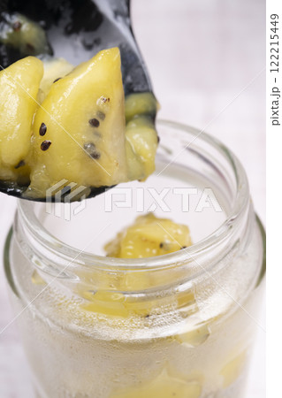 出来立てのキウイのジャムをガラス瓶に詰める 122215449