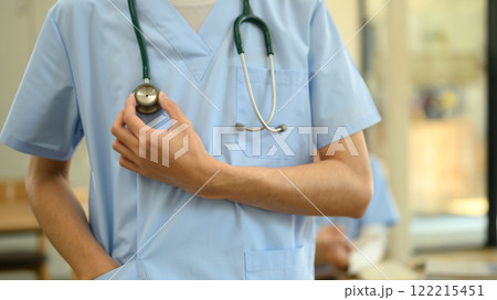 Close up view of healthcare worker wearing scrubs holding a stethoscope. Healthy care and medical concept 122215451