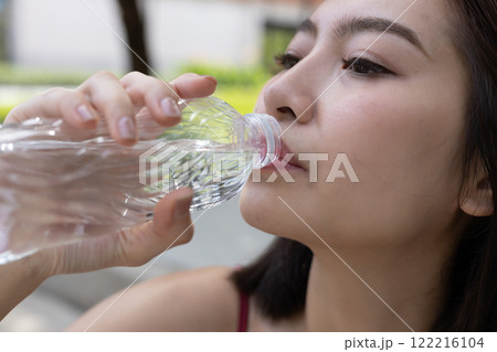 Asian young female sporty drinking water from water bottle while exercising. stay hydrated per day. Healthy fit woman fresh wellness. Drinking water makes you feel good. Asian young female sporty drinking water from water bottle while exercising. stay hydrated per day. Healthy fit woman fresh wellness. Drinking water makes you feel good. 122216104