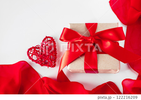 Gift box with craft paper and red ribbon on a white background Gift box with craft paper and red ribbon on a white background 122216209