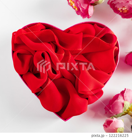 Red heart shaped gift box and flowers on white background Red heart shaped gift box and flowers on white background 122216225