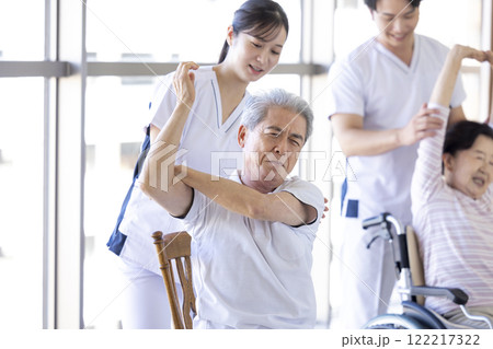 介護　理学療法士とストレッチするシニア 122217322