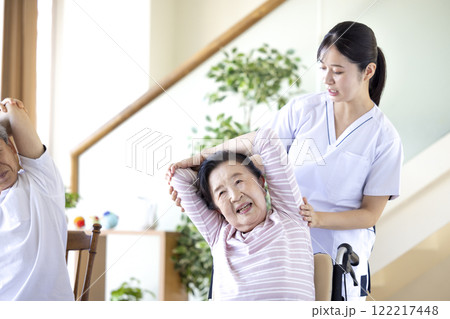 介護　理学療法士とストレッチするシニア 122217448