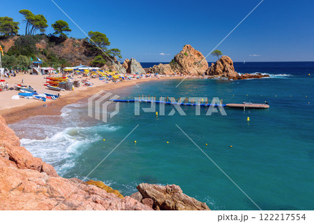 Rocky Coastline with Tree and Sailboat in Tossa de Mar, Spain Rocky Coastline with Tree and Sailboat in Tossa de Mar, Spain 122217554