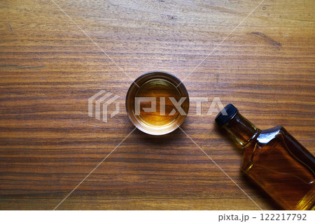 木製テーブルの上のウイスキーボトルとグラス 122217792