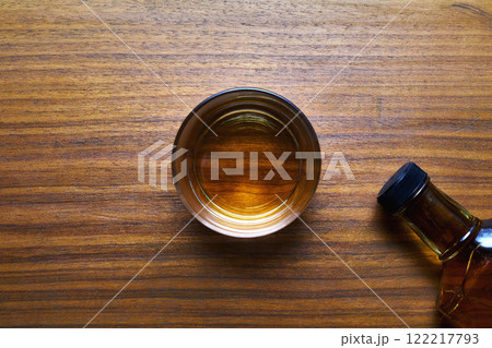 木製テーブルの上のウイスキーボトルとグラス 122217793
