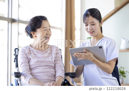 介護イメージ　シニア女性から聞き取りを行う看護師 122218026
